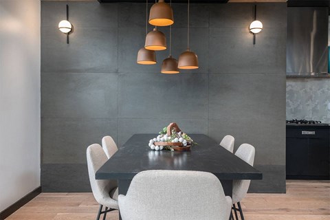 a dining room with a black table and white chairs