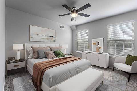 A bedroom with a large bed and a ceiling fan.