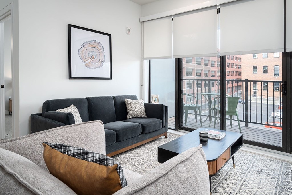 a living room with a couch and a sliding glass door to a balcony