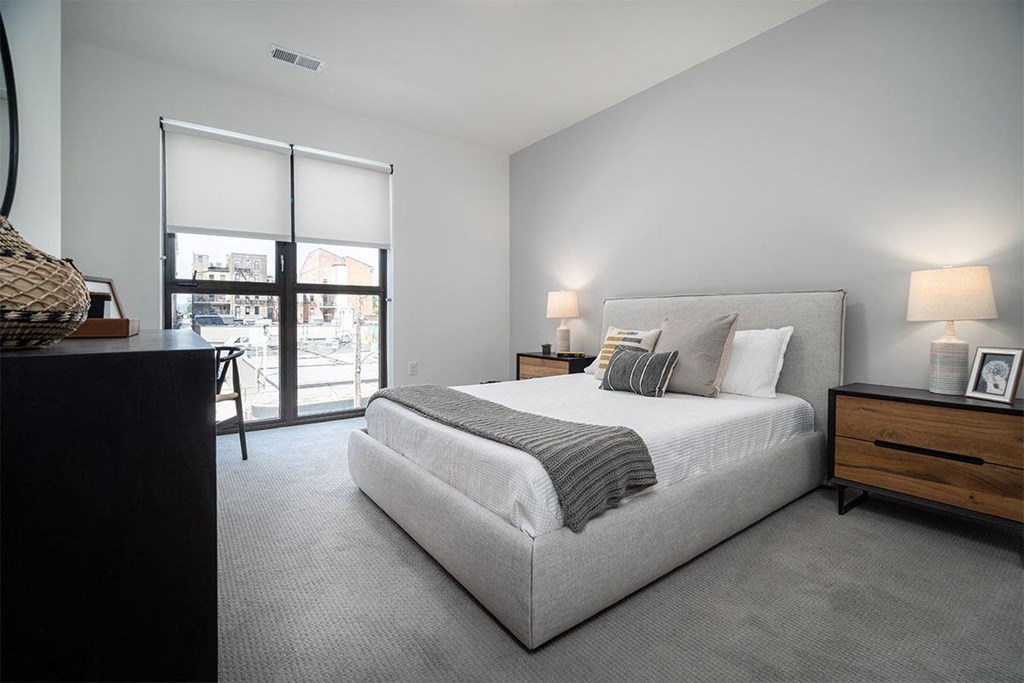 a bedroom with a bed and a large window