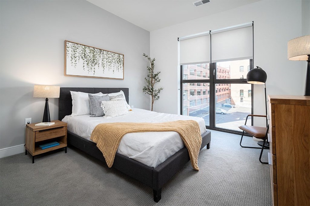 a bedroom with a bed and a large window