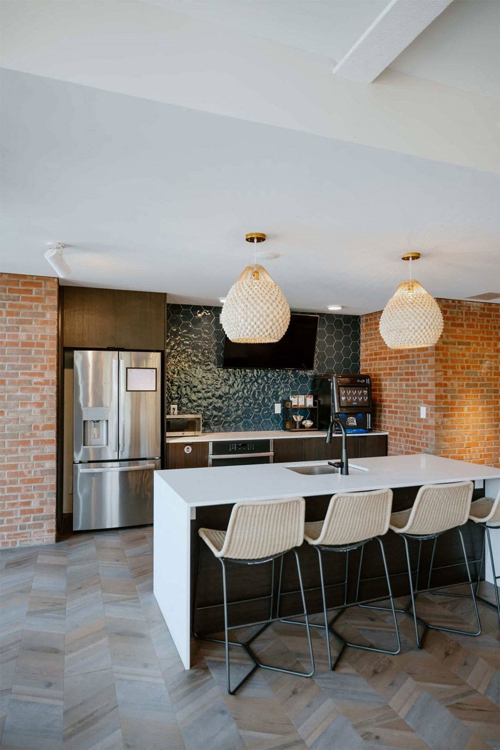 a kitchen with a large island and a stainless steel refrigerator