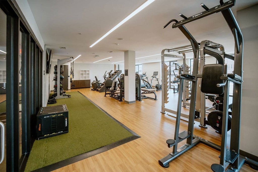 a gym with weights and other exercise equipment on a wooden floor