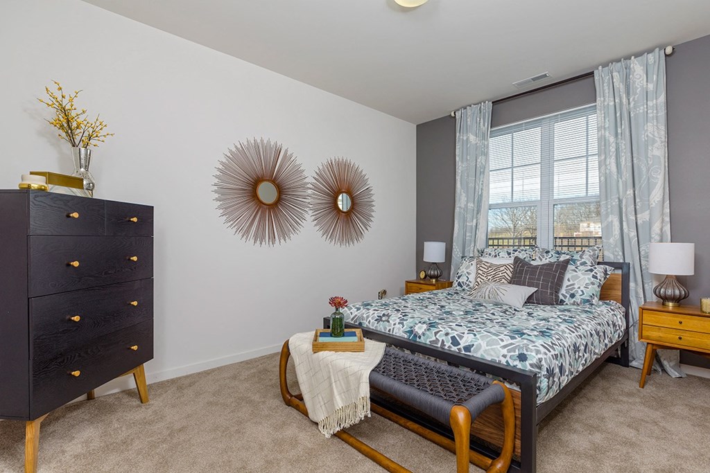 a bedroom with a bed and a dresser and a window