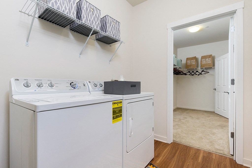 a washer and dryer in a laundry room with a door to a closet