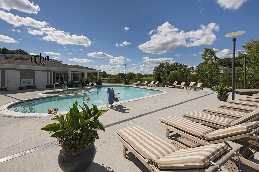 a swimming pool with lounge chairs and a building in the background