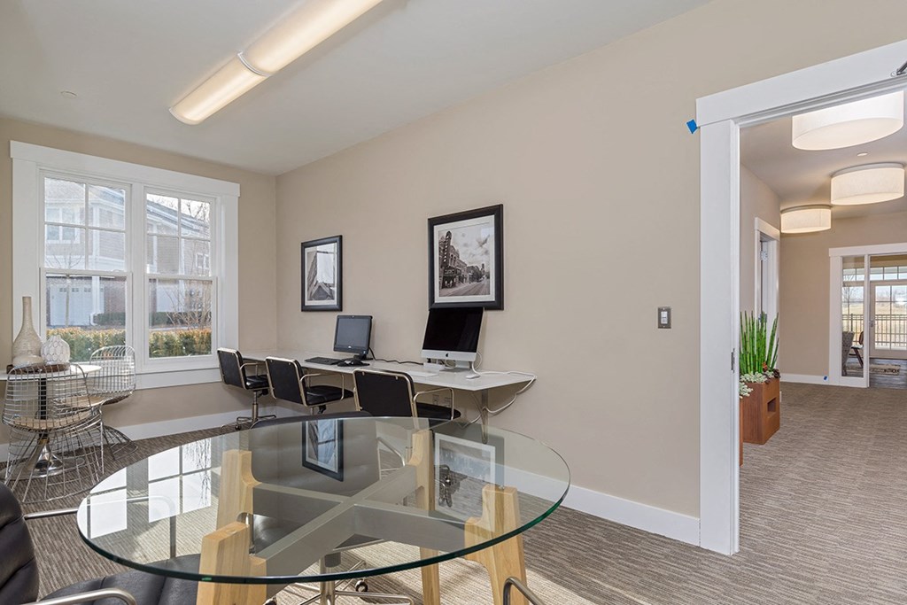 an office with a glass table and chairs and a window
