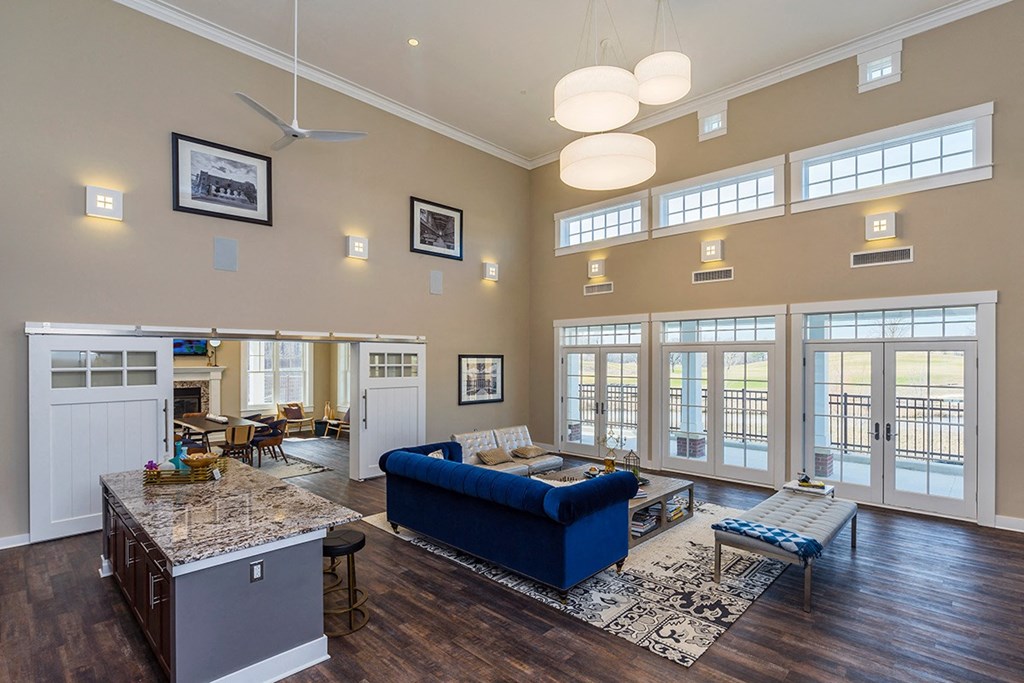 a large living room with a blue couch and a table