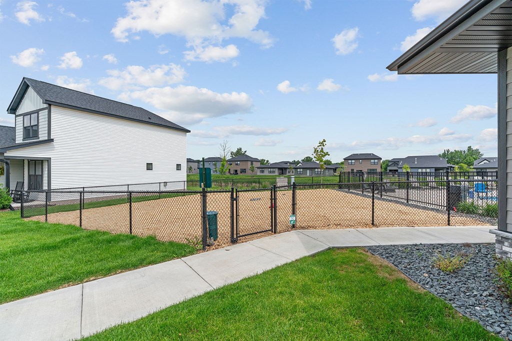 A white house with a black roof and a black fence.