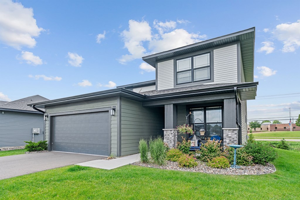 A modern house with a grey garage door and a grey front door.