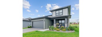 A modern house with a grey garage door and a grey front door.