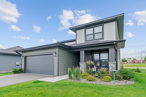 A modern house with a grey garage door and a grey front door.