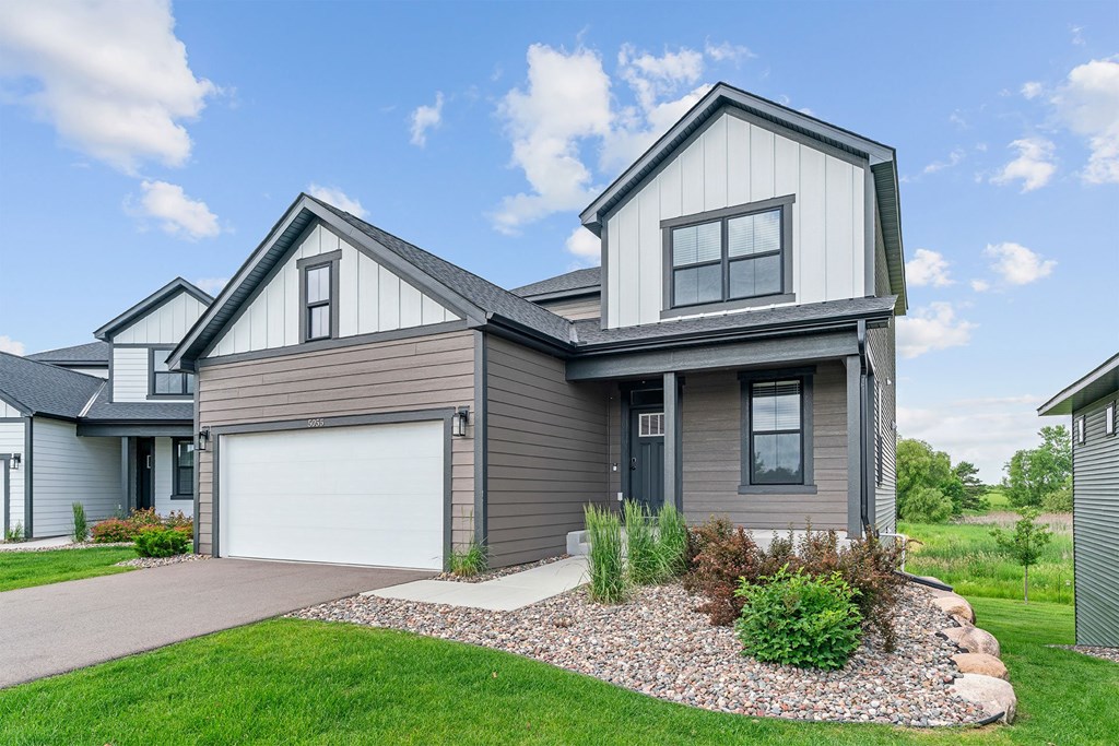 A modern house with a grey garage door and a grey roof.