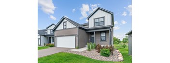 A modern house with a grey garage door and a grey roof.