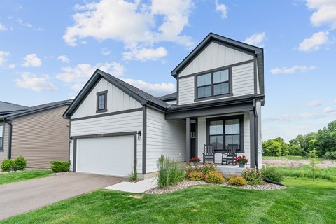 A modern house with a grey garage door and a white front door.