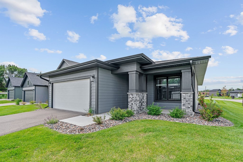 A modern house with a grey exterior and a stone pillar.