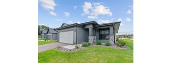 A modern house with a grey exterior and a stone pillar.