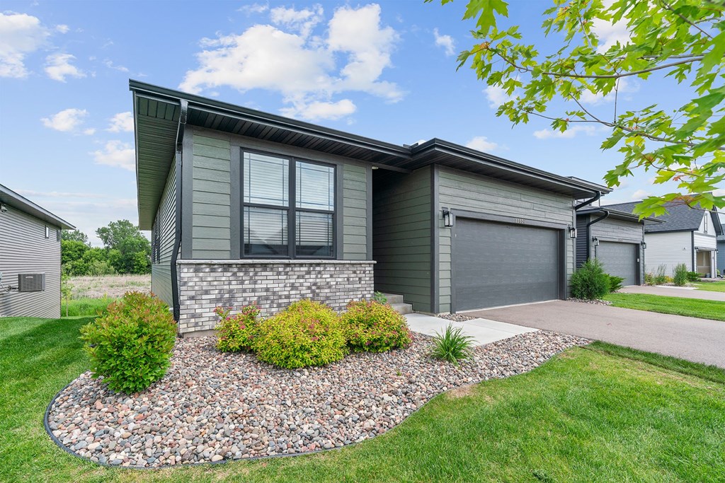 A house with a grey front yard and a gravel garden bed.