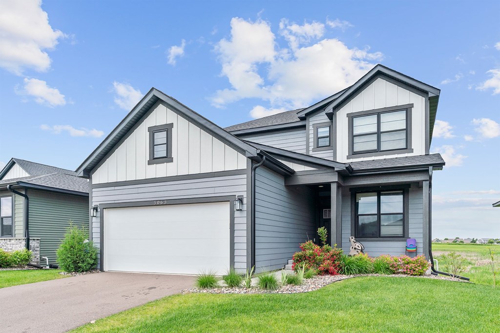 A modern house with a grey exterior and a white garage door.