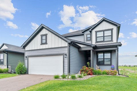 A modern house with a grey exterior and a white garage door.