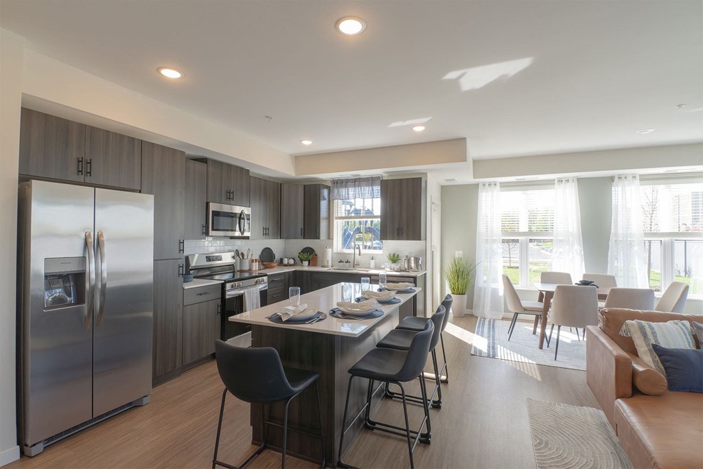 a kitchen and dining room with stainless steel appliances and a table and chairs