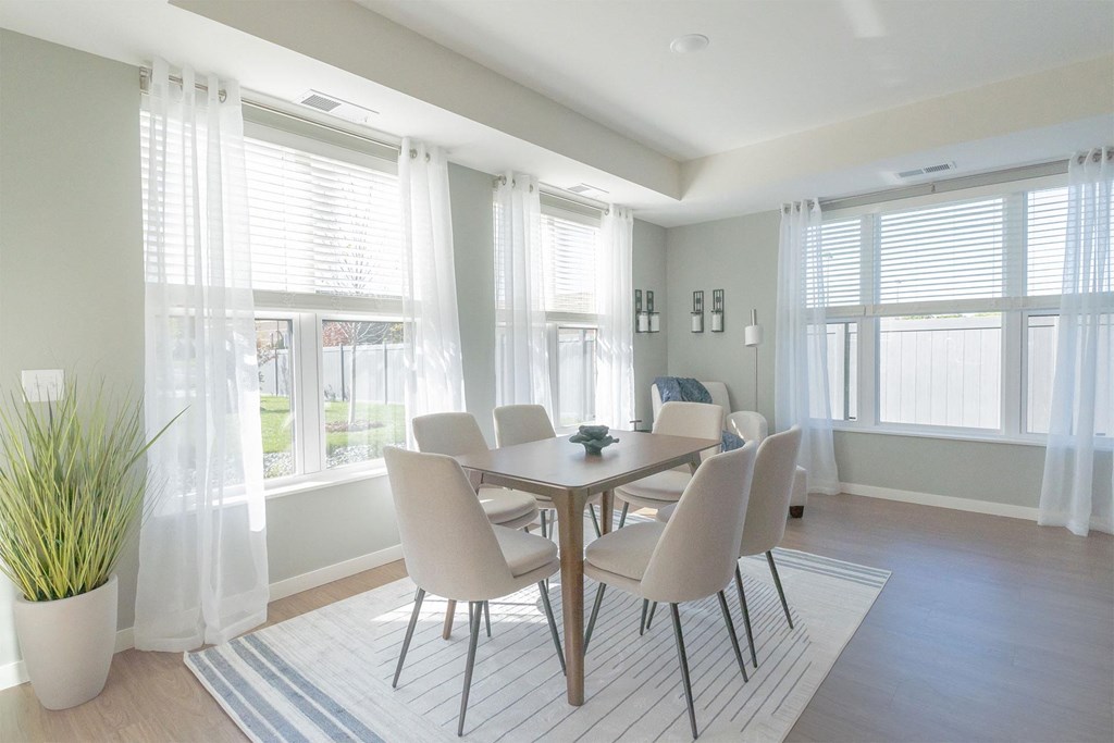 a dining room with a table and chairs and windows