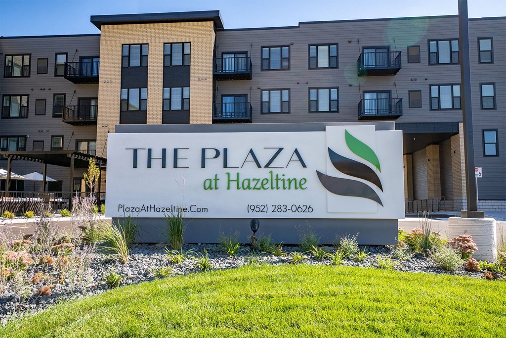a sign for the plaza at hackettle in front of an apartment building