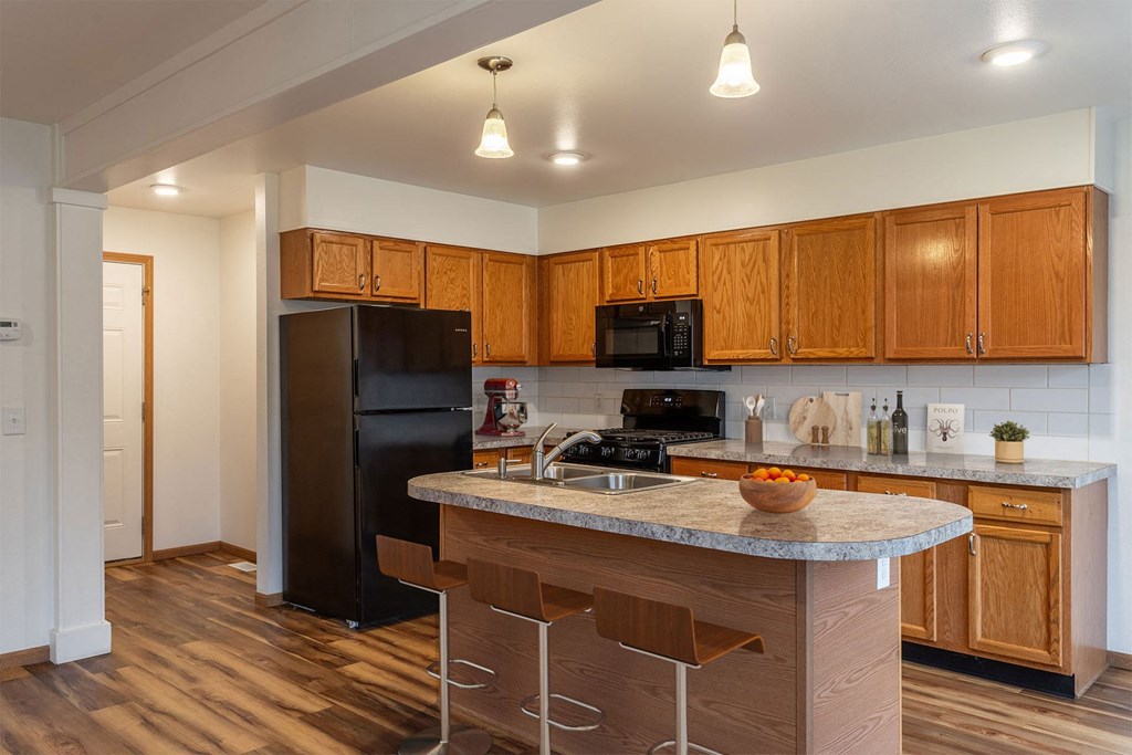 A kitchen with wooden cabinets and a granite countertop.