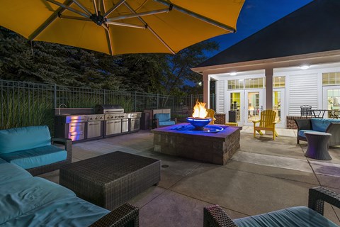 A patio with a fire pit and seating area.