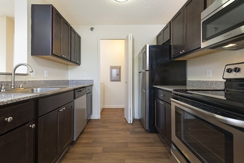 A kitchen with dark wood cabinets and stainless steel appliances.