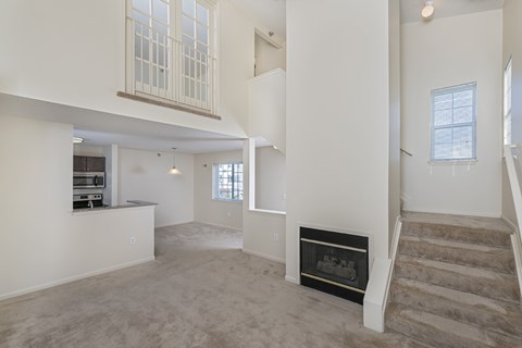 A living room with a fireplace and stairs leading to another floor.