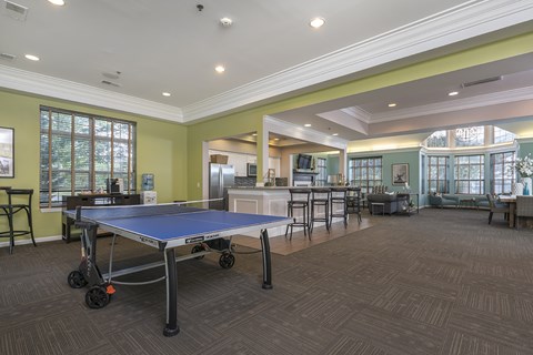 A blue pool table in a room with a carpeted floor.