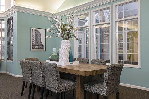 A dining room with a table and chairs.