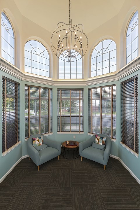 A living room with a large window and a chandelier.