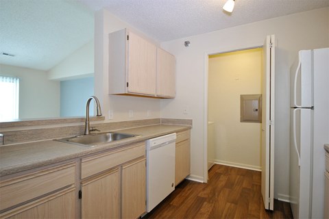 A kitchen with wooden cabinets and a white fridge.