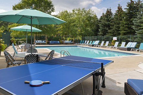 A blue table tennis table with a paddle on it.