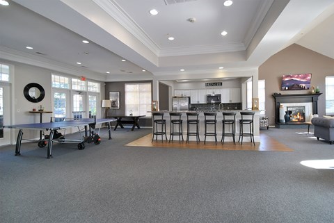 A spacious living room with a fireplace and a dining area with chairs and a table.