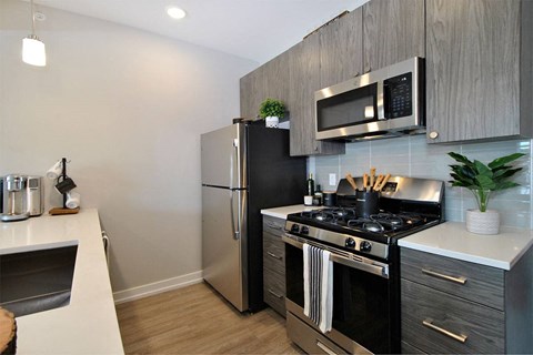 A modern kitchen with a black refrigerator, stove, and oven.