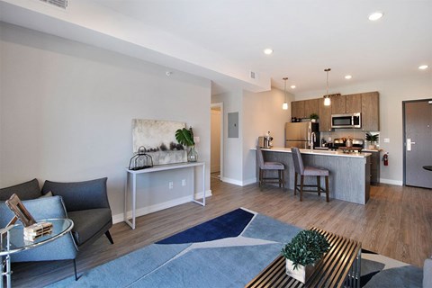 A modern kitchen with a breakfast bar and a dining table with chairs.