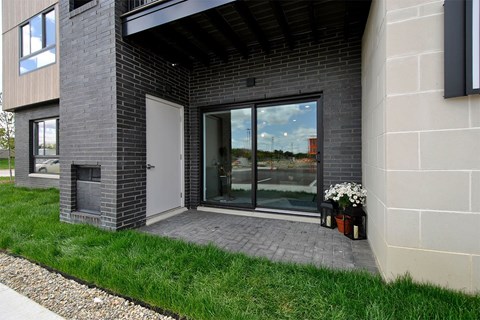 A modern house with a glass door and a brick wall.