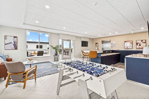 A foosball table is in the middle of a living room.