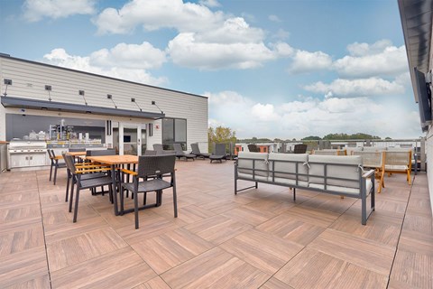 A wooden table and chairs are set up on a wooden deck.