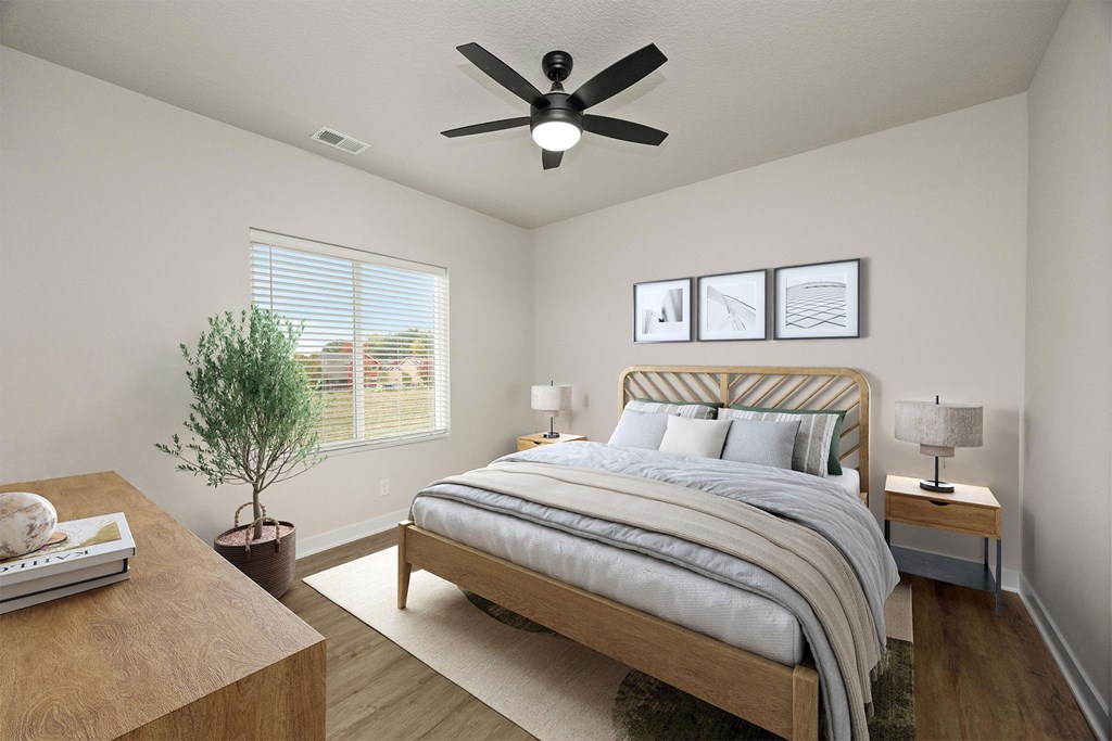 A bedroom with a bed, nightstand, and a ceiling fan.