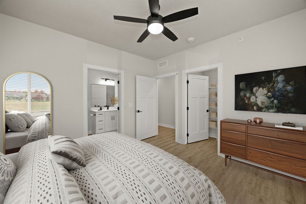 A bedroom with a large bed and a ceiling fan.