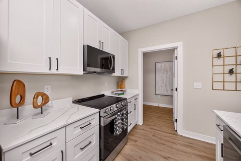 A kitchen with white cabinets and a black stove top.