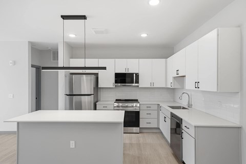 A modern kitchen with white cabinets and stainless steel appliances.