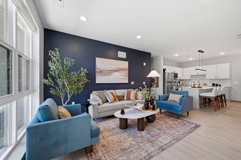 A living room with a blue couch and a rug.