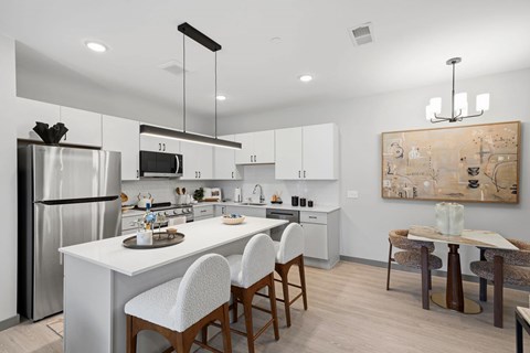 A modern kitchen with white cabinets and a large island.