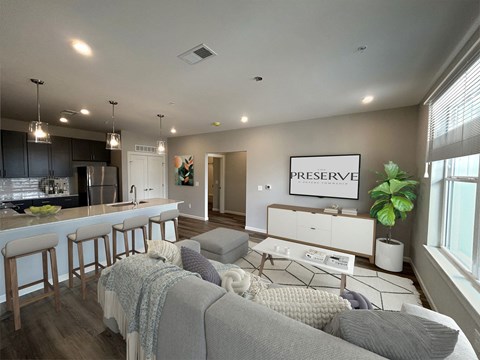 A modern living room with a grey couch and a bar area.