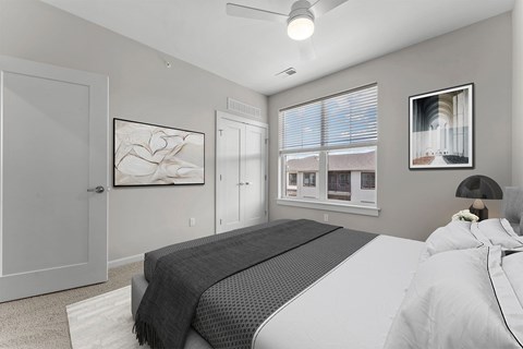 A bedroom with a large bed and a window overlooking a building.
